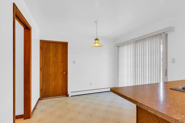 unfurnished dining area with light floors and baseboard heating