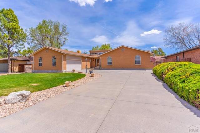 ranch-style home featuring driveway, a garage, fence, a front lawn, and brick siding