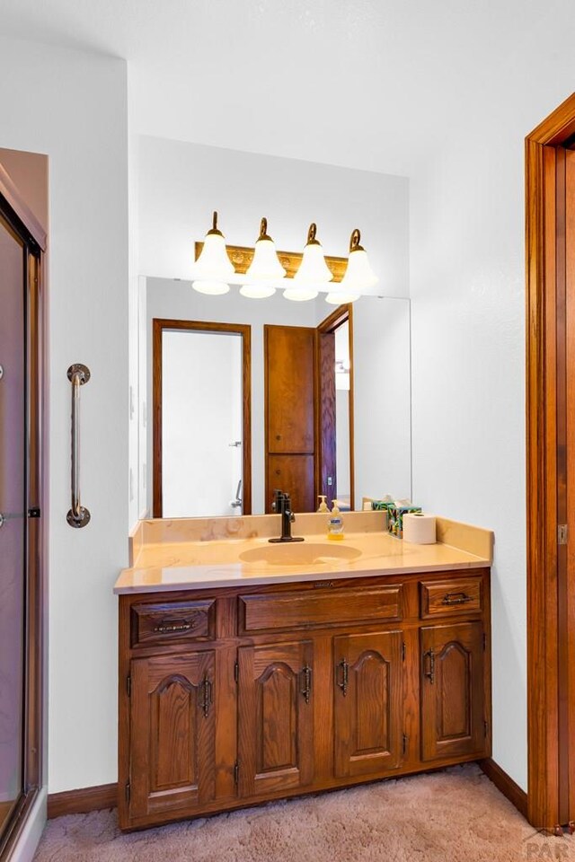 bathroom with an enclosed shower, carpet flooring, vanity, and baseboards