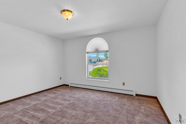 unfurnished room with baseboards, a baseboard radiator, and light colored carpet