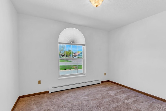 unfurnished room with a baseboard radiator, baseboards, and light colored carpet