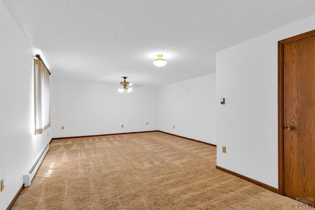 empty room with light carpet, baseboards, a baseboard heating unit, and a textured ceiling