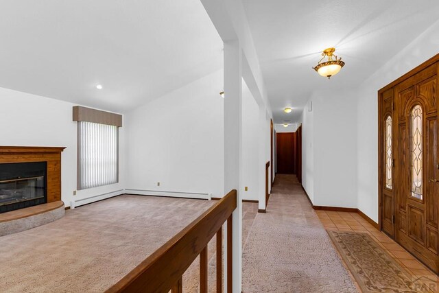 entryway featuring a glass covered fireplace, light carpet, baseboards, and light tile patterned flooring