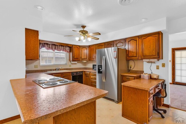 kitchen with ceiling fan, stainless steel appliances, brown cabinetry, and a peninsula