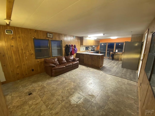 living area featuring wood walls and visible vents