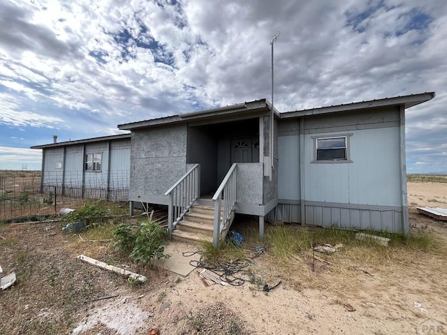 view of front of home with fence and metal roof