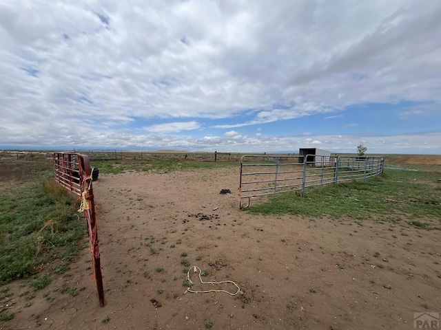 view of yard featuring a rural view, an outdoor structure, and an exterior structure