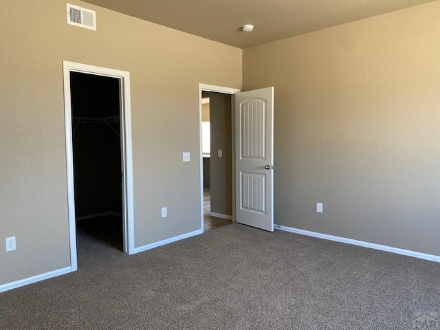 6221 Sawyer Ridge Dr, Pueblo, CO 81008 - unfurnished bedroom featuring a walk in closet, carpet flooring, baseboards, and a closet