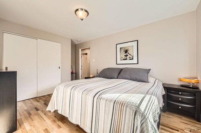 bedroom with light wood-type flooring and a closet