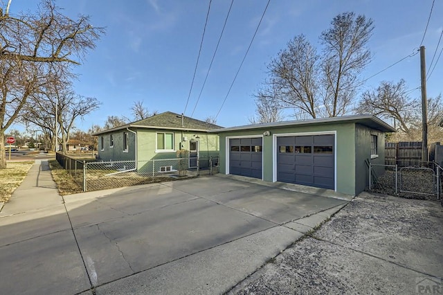 single story home featuring an outbuilding, a detached garage, fence, and stucco siding