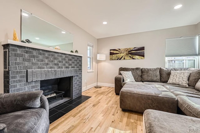 living room featuring recessed lighting, a fireplace, hardwood / wood-style flooring, and baseboards