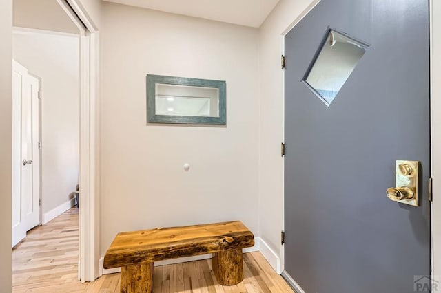 hall with light wood finished floors and baseboards