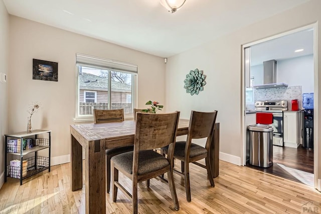 dining space featuring light wood-style floors and baseboards