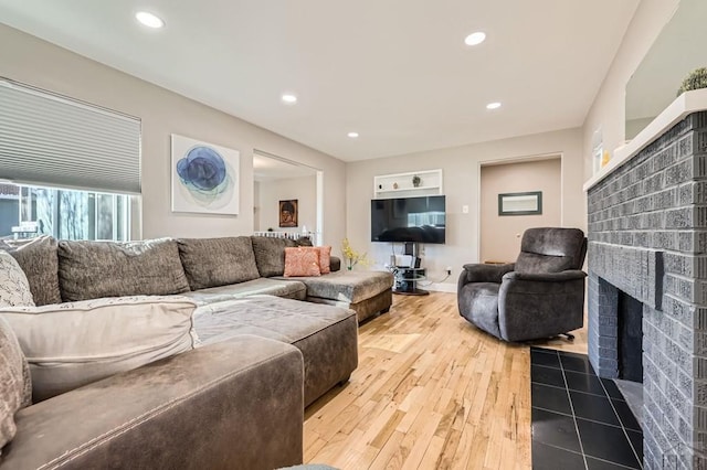 living area featuring a brick fireplace, wood-type flooring, and recessed lighting