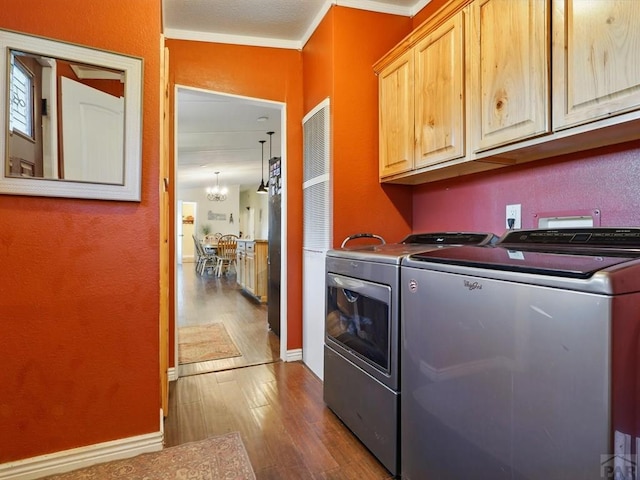 52825 E US Highway 50, Boone, CO 81025 - laundry room featuring cabinet space, independent washer and dryer, dark wood-style flooring, ornamental molding, and a chandelier