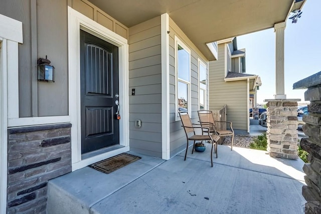 view of exterior entry featuring covered porch