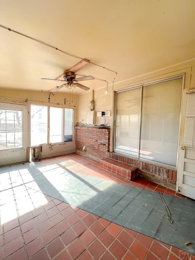 unfurnished sunroom featuring ceiling fan