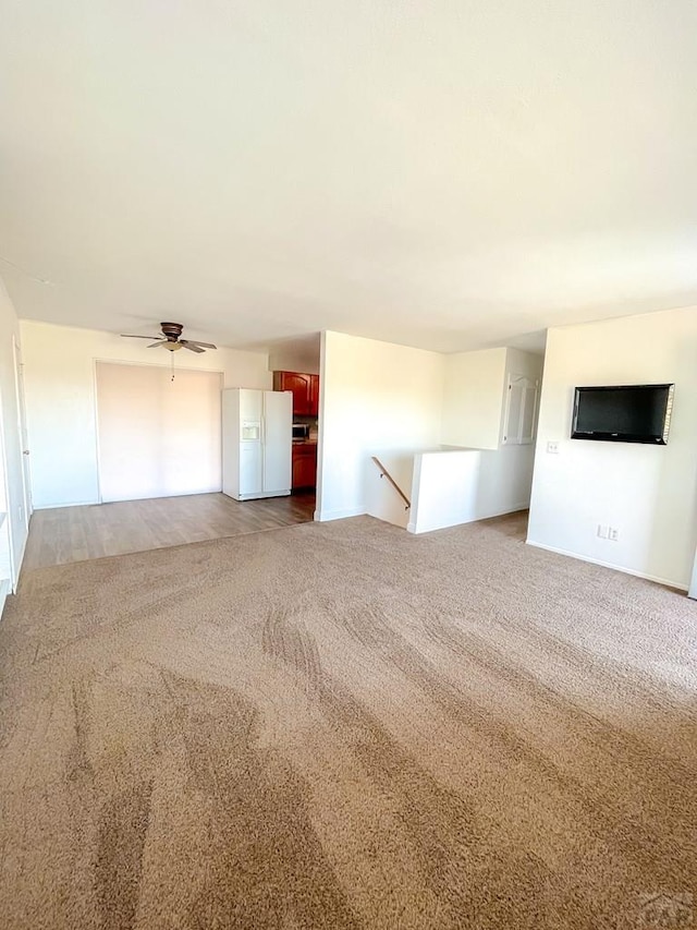 unfurnished living room with ceiling fan and carpet