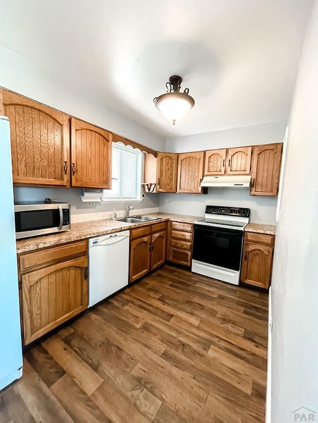 kitchen featuring under cabinet range hood, electric range, light countertops, dishwasher, and stainless steel microwave