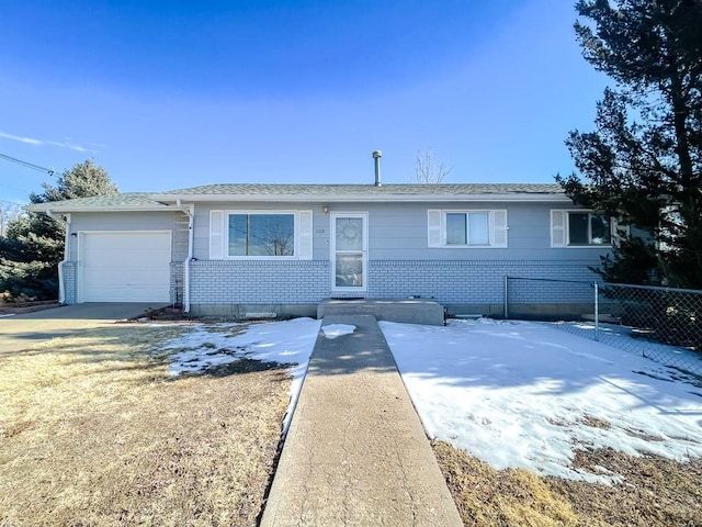 ranch-style home featuring driveway, brick siding, an attached garage, and fence