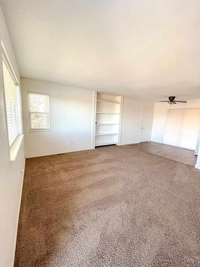 interior space with a ceiling fan and built in shelves