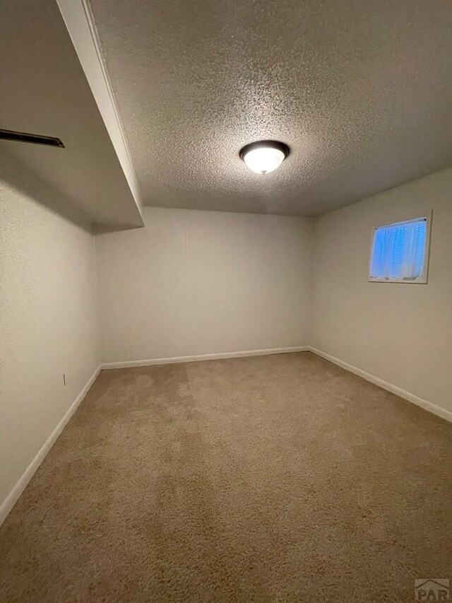 interior space with carpet, a textured ceiling, and baseboards