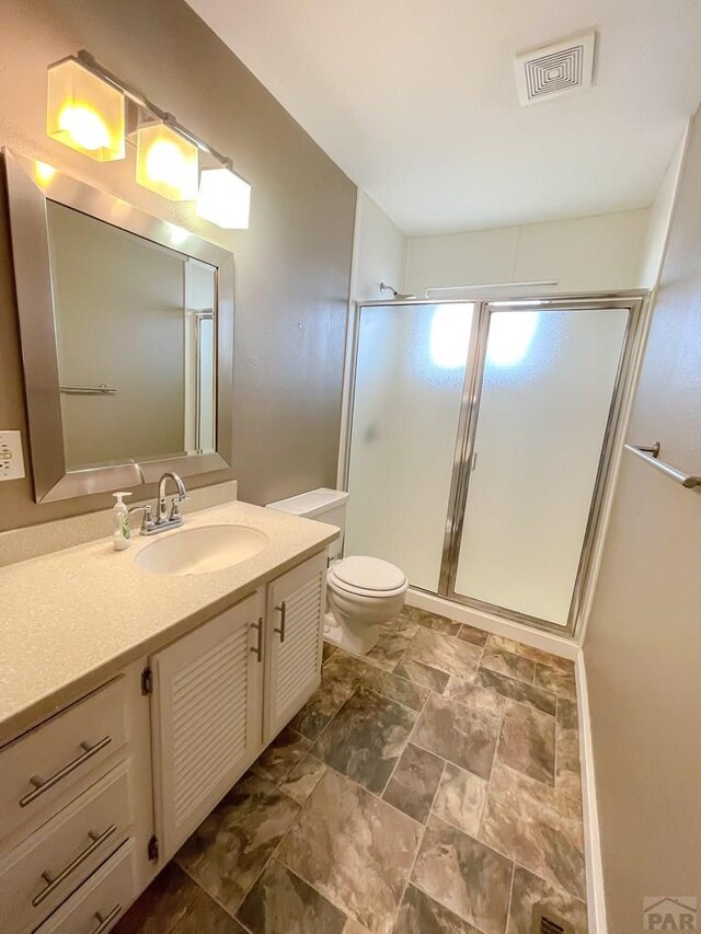 full bath with a stall shower, visible vents, vanity, and toilet