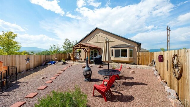 exterior space with a patio area, a fenced backyard, a mountain view, and stucco siding