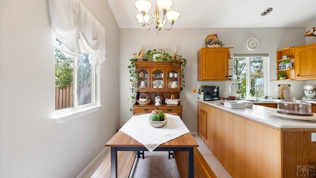 kitchen with pendant lighting, a notable chandelier, open shelves, light countertops, and a sink