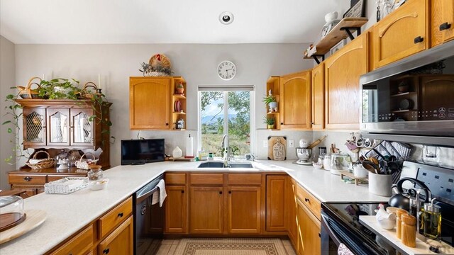 kitchen featuring brown cabinets, light countertops, black appliances, open shelves, and a sink