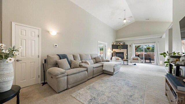 living room featuring light carpet, ceiling fan, high vaulted ceiling, and a glass covered fireplace