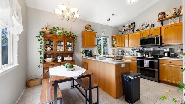 kitchen featuring visible vents, stainless steel appliances, light countertops, and decorative light fixtures