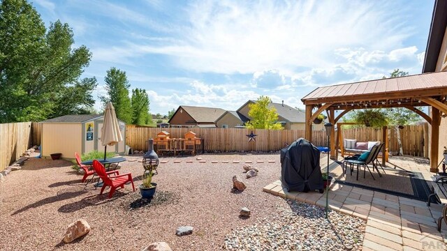 view of yard with an outbuilding, a patio, a gazebo, a storage shed, and a fenced backyard