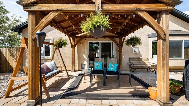 view of patio featuring fence and a gazebo