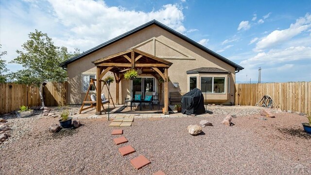 back of property with a patio area, a fenced backyard, and stucco siding