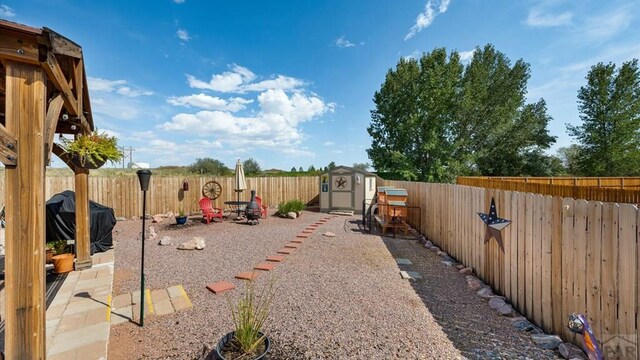 view of yard featuring an outbuilding, a fenced backyard, and a shed