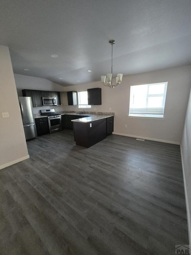 kitchen with baseboards, appliances with stainless steel finishes, open floor plan, dark wood-style flooring, and light countertops