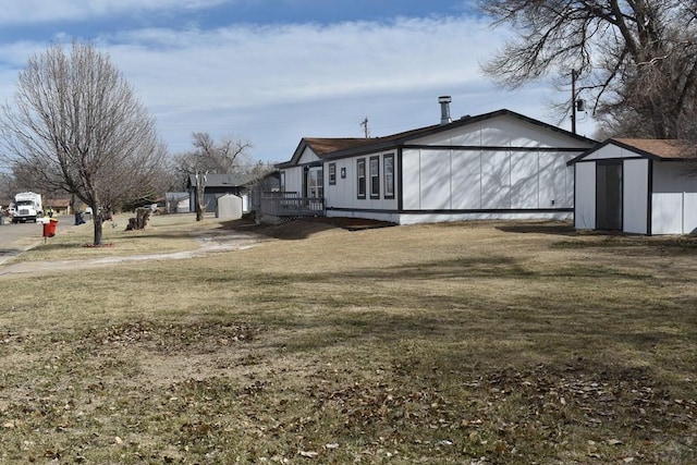 view of side of home with a shed, a lawn, and an outdoor structure