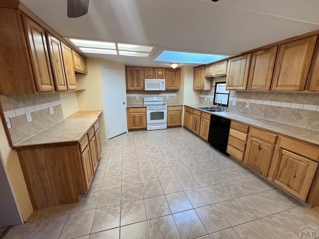 kitchen featuring white appliances, a sink, a ceiling fan, tile counters, and decorative backsplash