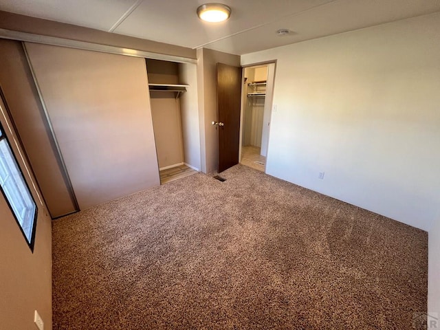 unfurnished bedroom with a closet and carpet flooring