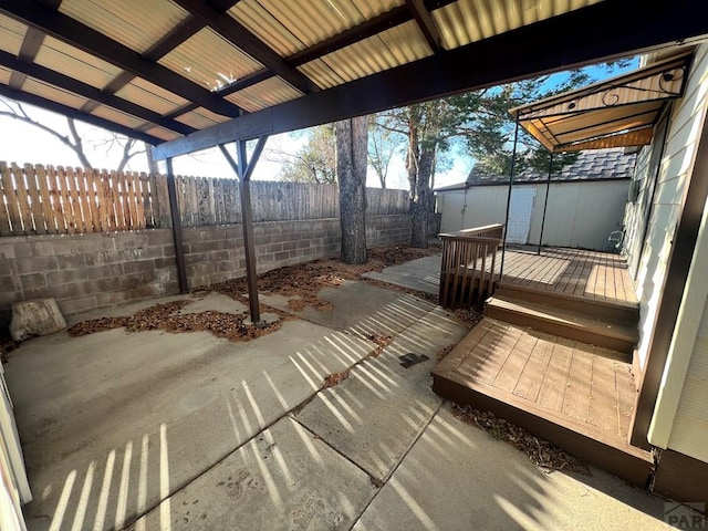 exterior space featuring a storage shed, a fenced backyard, a patio area, and an outbuilding