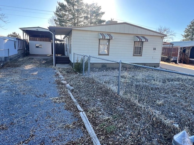 exterior space with a carport, fence, and driveway