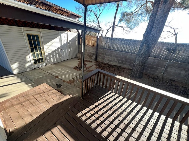 wooden terrace with a fenced backyard