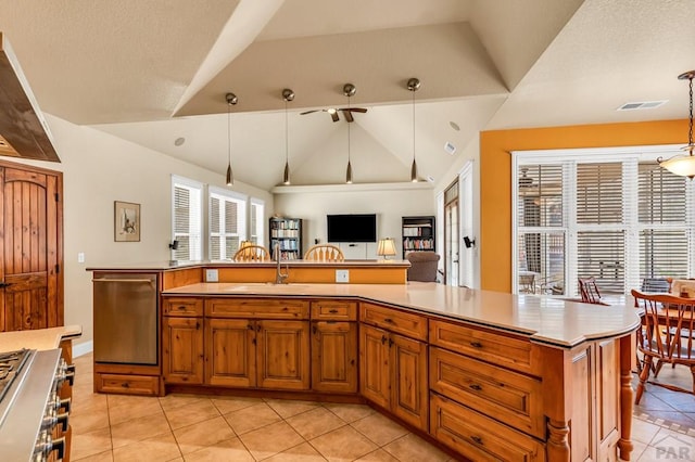 611 Rock Ridge Loop, Canon City, CO 81212 - kitchen featuring stainless steel dishwasher, vaulted ceiling, light tile patterned floors, a sink, and brown cabinets