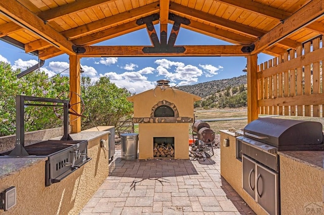 611 Rock Ridge Loop, Canon City, CO 81212 - view of patio / terrace with exterior fireplace, area for grilling, a mountain view, and a gazebo