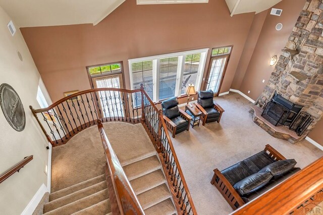 611 Rock Ridge Loop, Canon City, CO 81212 - stairway featuring carpet, a stone fireplace, a high ceiling, and baseboards