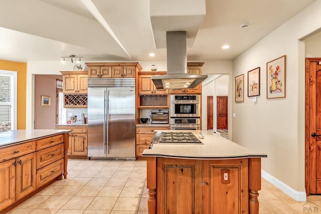 611 Rock Ridge Loop, Canon City, CO 81212 - kitchen featuring stainless steel appliances, island range hood, light tile patterned floors, tasteful backsplash, and light countertops