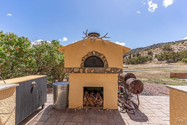 611 Rock Ridge Loop, Canon City, CO 81212 - view of patio / terrace featuring an outdoor fireplace and a mountain view