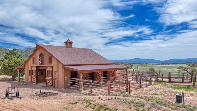 view of stable with a rural view and a mountain view