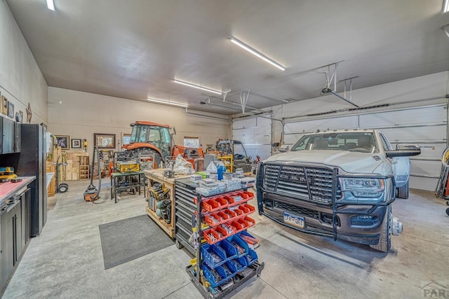 garage with a workshop area and freestanding refrigerator